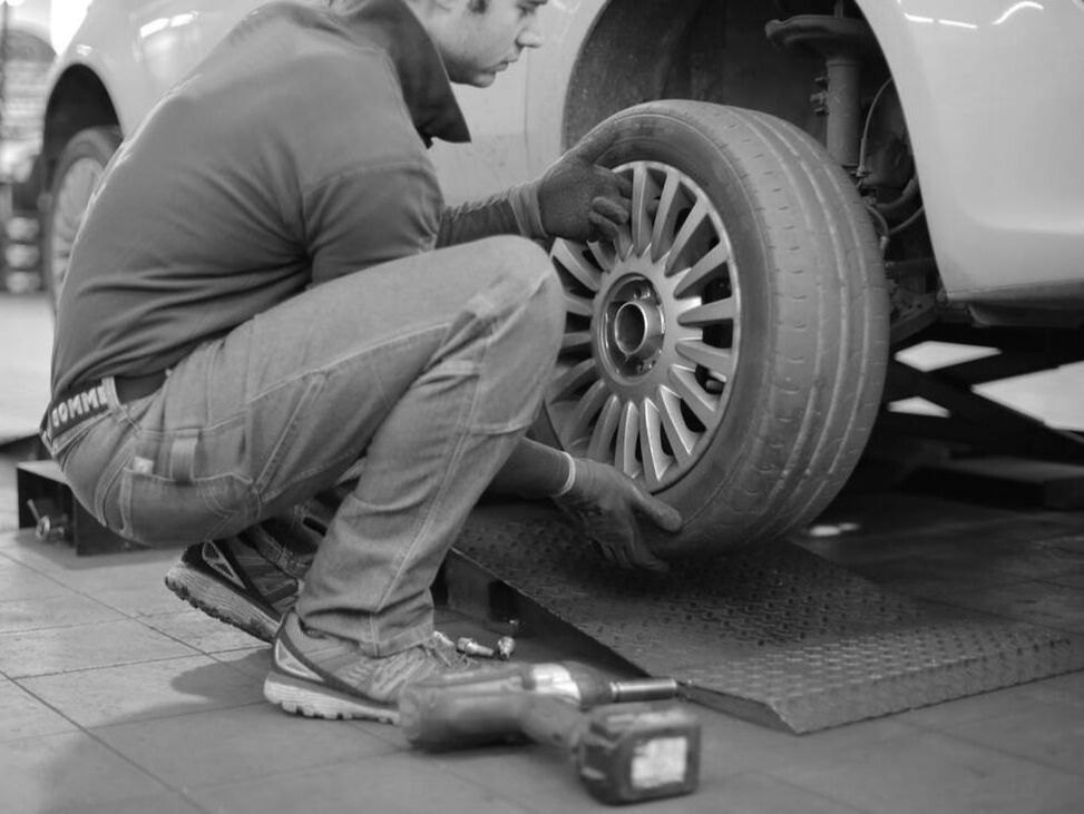 Mechanic installing tires on vehicle